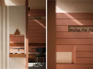 A modern, minimalist coffee shop with wooden walls featuring an 'enjoy the moment' sign.