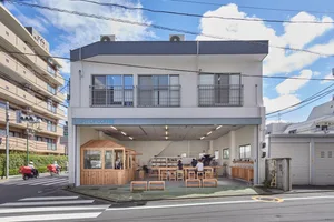 A modern coffee shop exterior featuring wood, concrete, and glass materials.
