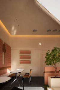 Modern restaurant interior with concrete and terrazzo finishes, featuring minimalist design elements and sleek lines.