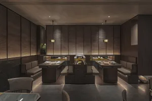 Modern restaurant interior featuring minimalist design with wooden seating and rock elements.