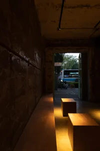 An industrial-style interior featuring a wooden bench and concrete floor.