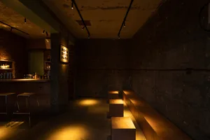 A dimly lit, industrial-style bar with exposed brick walls.
