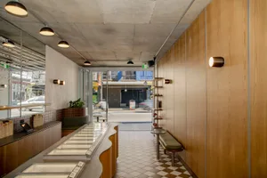 Minimalist restaurant interior with wood paneling, checkered floor, and industrial lighting