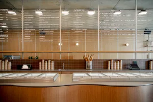 Modern restaurant interior with a wooden counter displaying ice cream flavors.