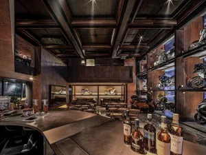 A modern, industrial-themed motorcycle shop and bar with metal elements and motorcycles displayed on shelves and walls.