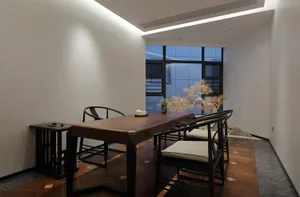 Modern living room featuring wooden furniture and a bonsai tree in a minimalist setting.