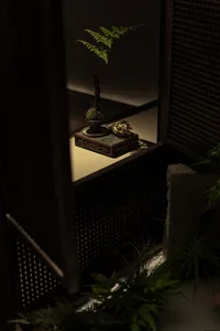 A traditional indoor decoration featuring a wooden cabinet with a plant and decorative items.