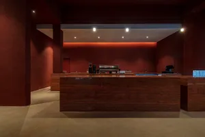 A modern coffee shop interior with a dark wooden counter and minimalist design.