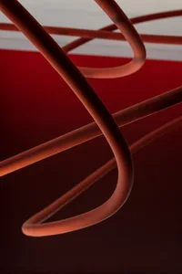 Red copper pipes arranged in a minimalist pattern against a dark background.