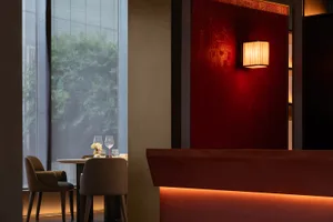 A modern restaurant interior featuring wooden furniture and glass walls.