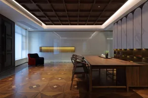 A modern office space featuring a wooden table, chairs, and a red armchair near a large window.