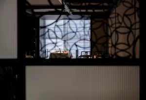 A restaurant interior with a glass-etched window displaying intricate patterns.