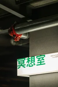 A metal pipe with a sign attached, featuring green Chinese characters.