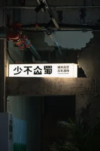 A minimalist signage with illuminated characters on a dark, industrial background.