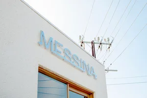 The Messina building exterior features clean white walls with blue signage reading "Messina"