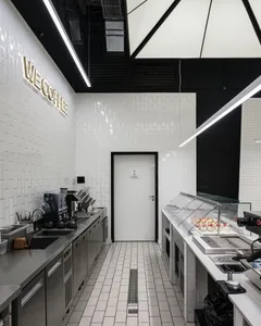 Modern minimalist cafe interior with white tiles and metallic fixtures