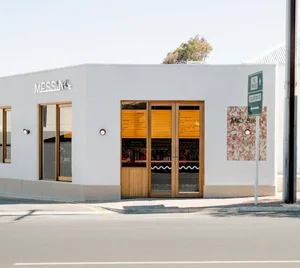 A minimalist storefront with a concrete exterior and large windows.