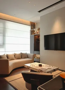 A modern living room featuring a contemporary sofa, marble coffee table, and concrete accents.