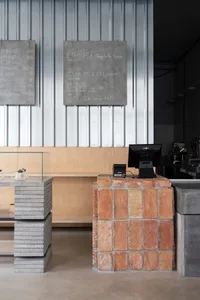 A modern coffee shop interior with a concrete and brick wall