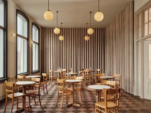 Dining room with modern wooden furniture and round tables.