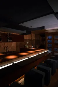 A modern restaurant bar with wooden interiors, neon lights, and comfortable seating