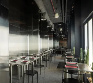 Modern, minimalist restaurant interior with metallic countertops and chairs.