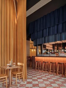 Interior of an industrial-themed restaurant featuring copper, leather, and wooden materials