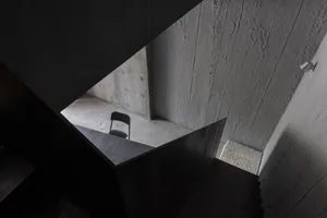A minimalist interior space with concrete walls and floors.