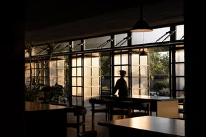 A modern cafeteria interior featuring glass windows and interior design elements.