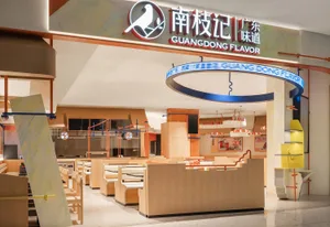 Modern food court interior with contemporary design elements, featuring tables, chairs, and signage.