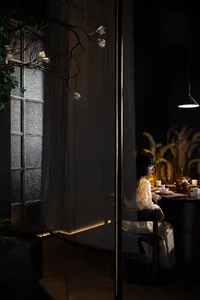 A sleek, modern restaurant booth constructed with metal netting and illuminated from below, featuring a minimalist interior d