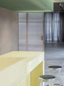 A modern bar area with a yellow countertop and concrete floor.