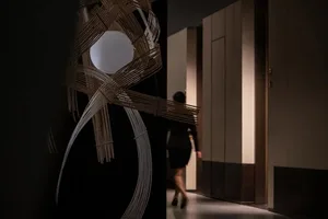A corridor with modern industrial decor, featuring wooden beams, light fixtures, and minimalist design.