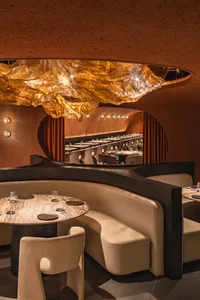 Circular table and cushioned seating arrangement in a modern restaurant interior.