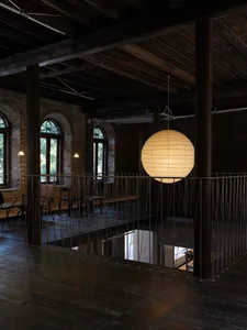 Industrial interior with wooden floors, brick walls, and metal railings.