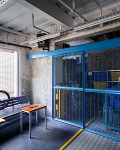 An industrial warehouse interior with a metal gate and concrete walls.