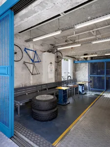 A minimalist workspace with concrete and metal walls and a polished concrete floor.