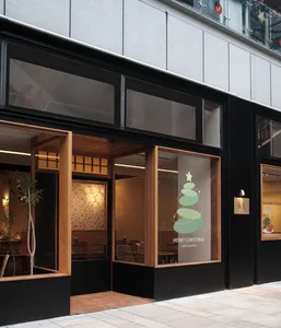 Modern retail storefront with large glass windows displaying festive holiday decorations.