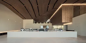 A minimalist coffee shop interior features concrete and wooden elements, with a sleek, contemporary design.