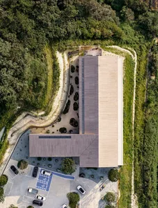 Aerial view of a modern office with a wooden exterior and a stone path leading to a parking area.