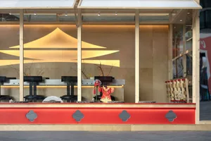 Modern restaurant interior featuring wooden walls and red accents