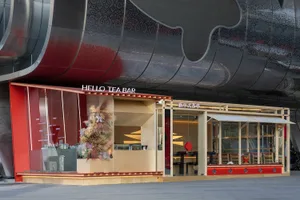 Modern restaurant exterior with wooden facade, glass panels, and metallic accents