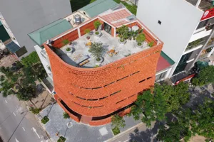 An aerial view of a modern rooftop garden featuring brick walls and a variety of plants.