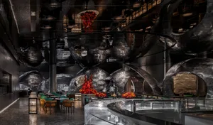 Modern industrial restaurant interior with metallic and glass elements.
