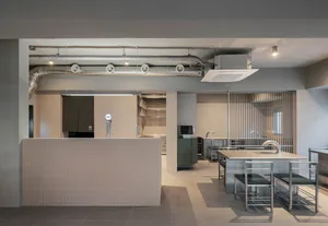 Industrial-style commercial kitchen space with metal counters and tiled walls.