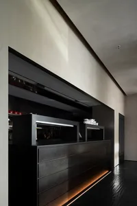 A sleek, modern black kitchen counter with minimalist design and hidden lighting beneath the surface.