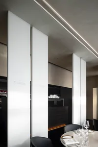Decorative white panels in a modern restaurant interior with dark wood accents.