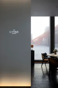 Modern, minimalist restaurant interior with large windows, wooden floors, and contemporary furniture.