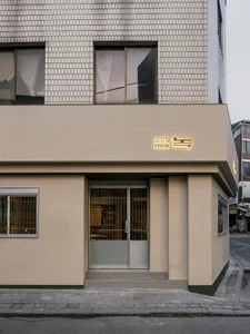 Modern retail storefront with concrete facade and glass doors.