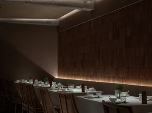 Dining area in a modern restaurant with wooden walls and white tablecloths